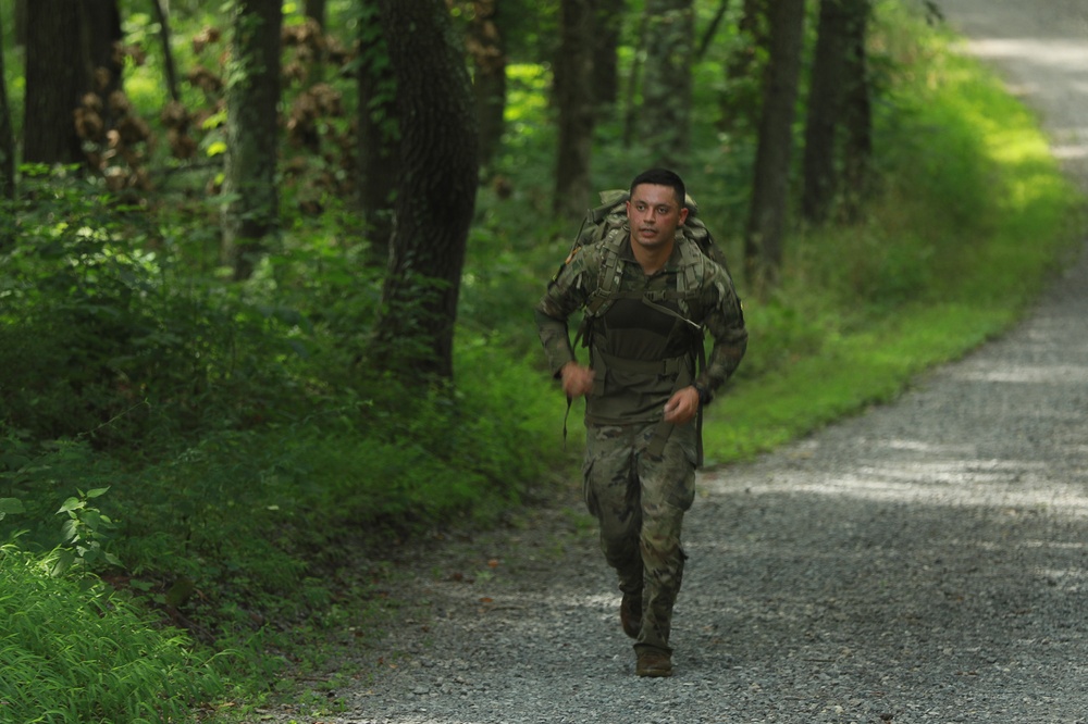 Sgt. Robert Ruiz-Rhoads runs with rucksack in river operations - 2025 National Best Warrior