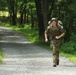 Spc. Adam Andrews runs with rucksack in river operations - 2025 National Best Warrior