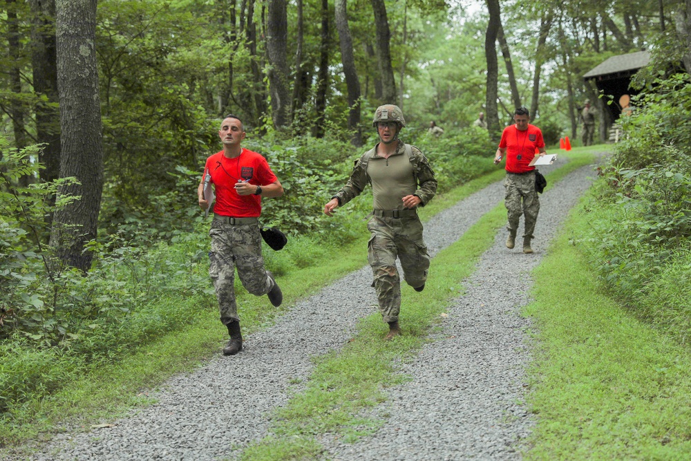 Sgt. 1st Class Matija Ivakovic and Sgt. 1st Class Miroslav Durdevic sprint with competitor - 2025 National Best Warrior