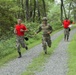 Sgt. 1st Class Matija Ivakovic and Sgt. 1st Class Miroslav Durdevic sprint with competitor - 2025 National Best Warrior