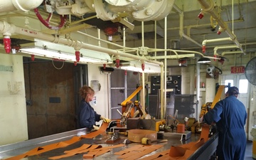 Radford Army Ammunition Plant employee in roll powder line rolling strips of ammunition