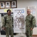 NSCS Executive Officer CDR Jennifer Charlton (left) and artist ENS Joseph Montano (right) stand next to an illustration containing the full crew of the USS Duarte (DDG 250)