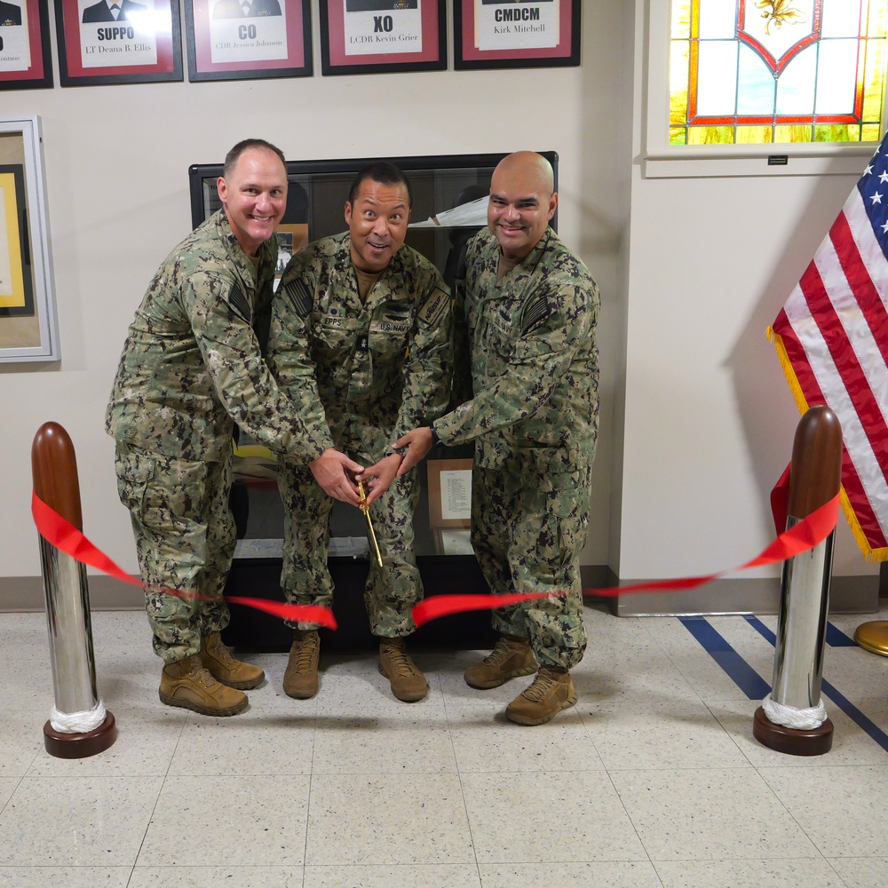 NSCS CO CAPT T. Richie Jenkins (left), RADM Ken Epps (center) and ENS Joseph Montano (right) cut the commissioning ribbon