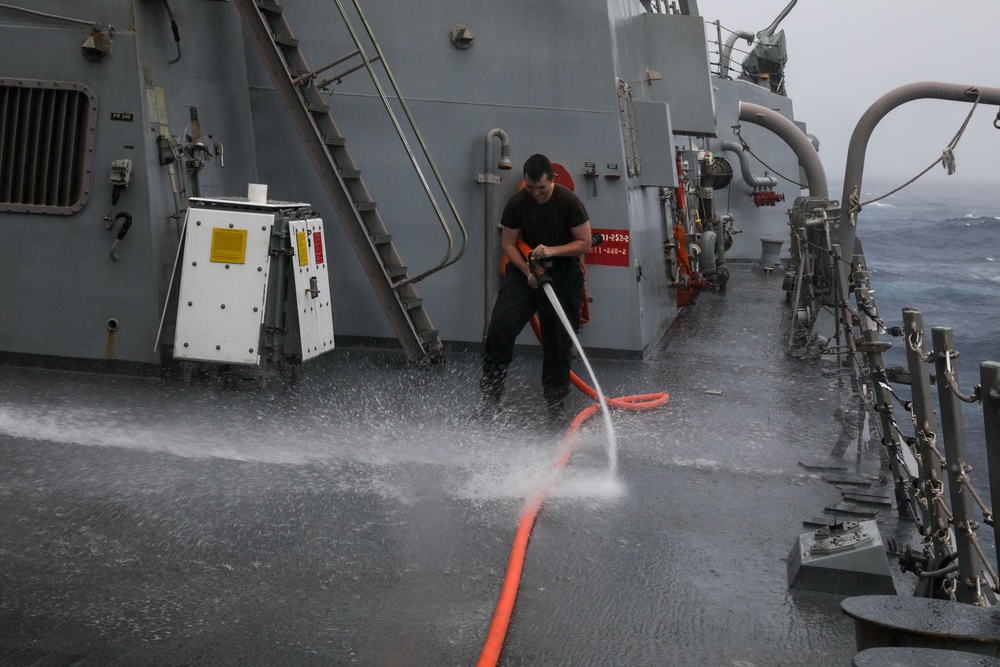 Sailors aboard the USS John Finn conduct a freshwater wash down in the Indian Ocean