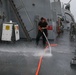 Sailors aboard the USS John Finn conduct a freshwater wash down in the Indian Ocean