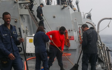 Sailors aboard the USS John Finn conduct a freshwater wash down in the Indian Ocean