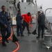 Sailors aboard the USS John Finn conduct a freshwater wash down in the Indian Ocean