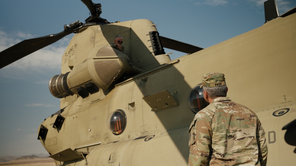 Command Sgt. Maj. Jasen Pask, speaks with a 1-111th Aviation Regiment UH-47 Chinook crewmember at their arrival at Fort Irwin