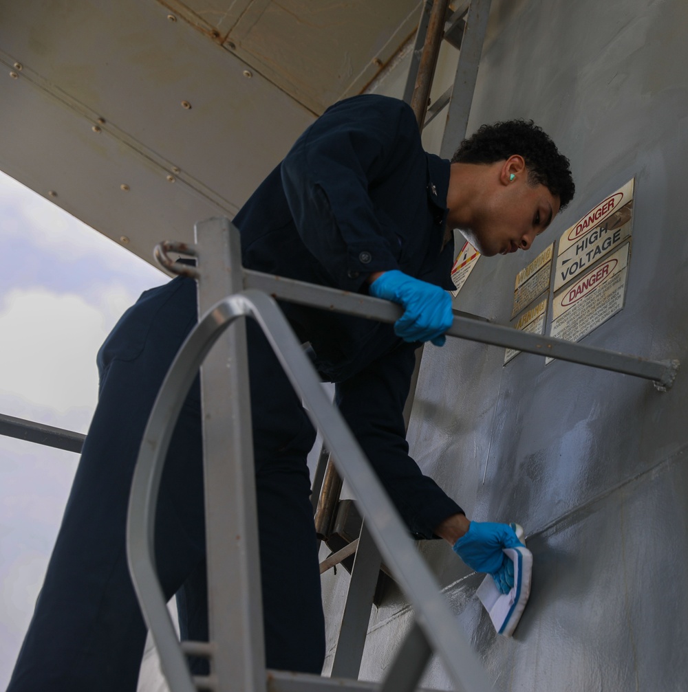 Sailors aboard the USS John Finn conduct topside preservation efforts in the Indian Ocean
