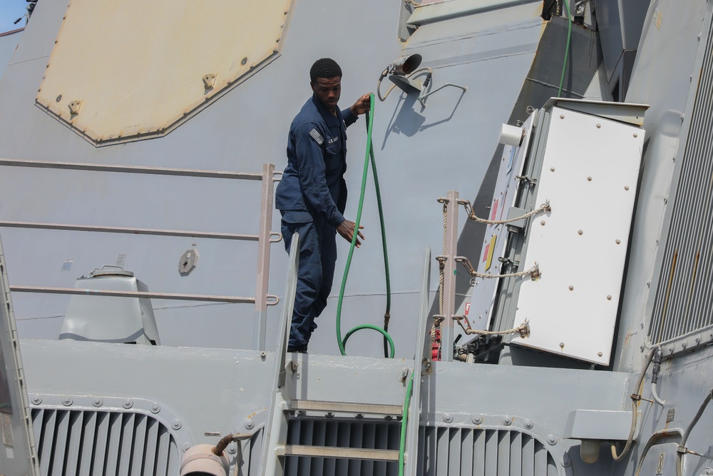 Sailors aboard the USS John Finn conduct topside preservation efforts in the Indian Ocean