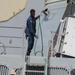 Sailors aboard the USS John Finn conduct topside preservation efforts in the Indian Ocean