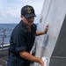 Sailors aboard the USS John Finn conduct topside preservation efforts in the Indian Ocean