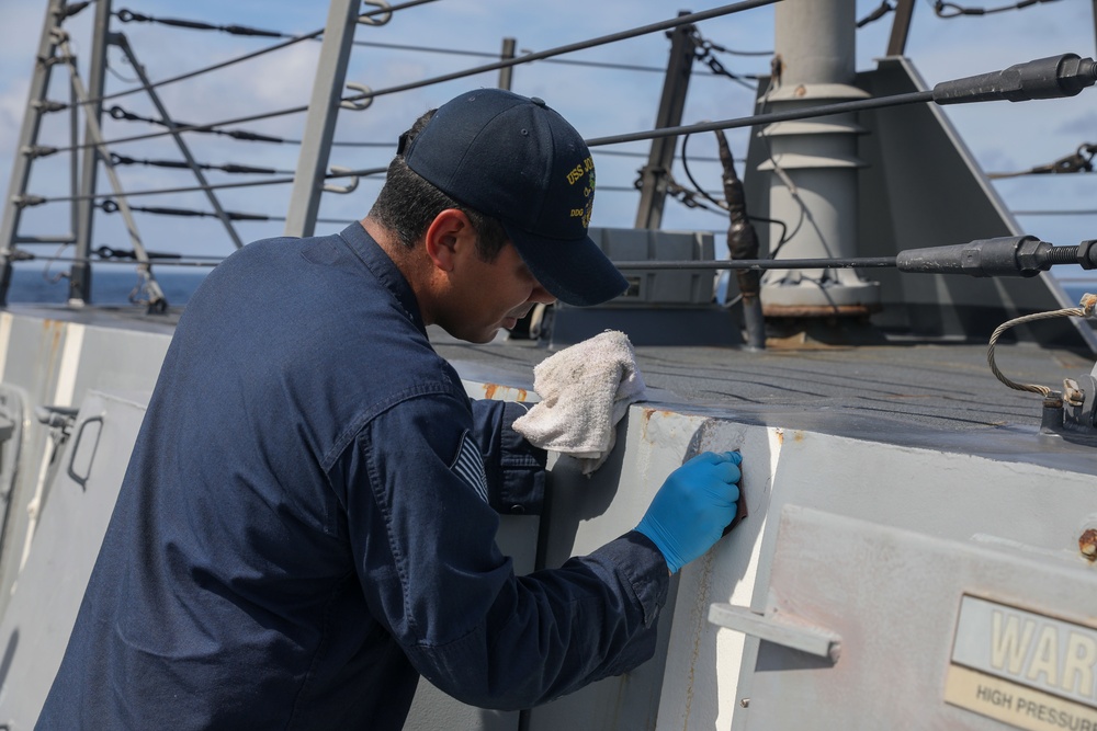 Sailors aboard the USS John Finn conduct topside preservation efforts in the Indian Ocean