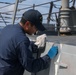 Sailors aboard the USS John Finn conduct topside preservation efforts in the Indian Ocean