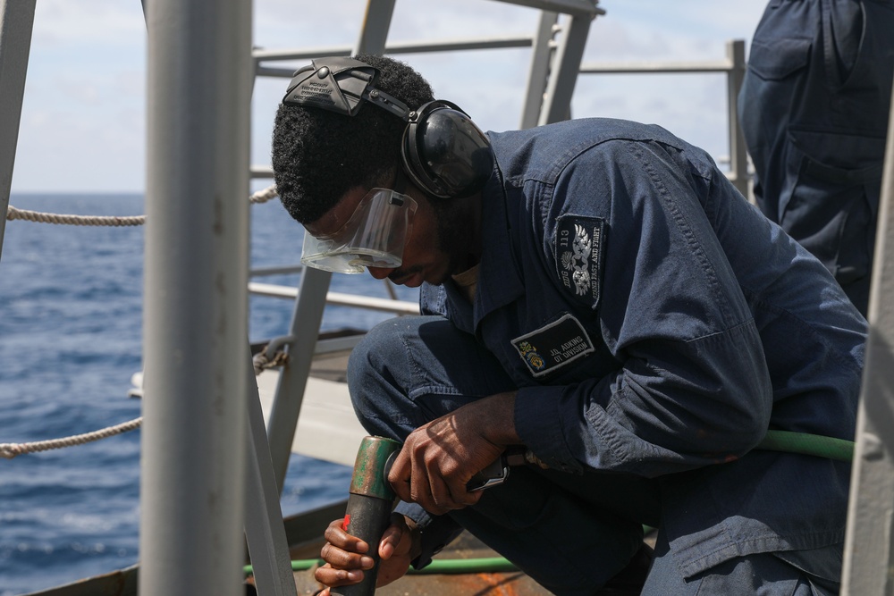 Sailors aboard the USS John Finn conduct topside preservation efforts in the Indian Ocean
