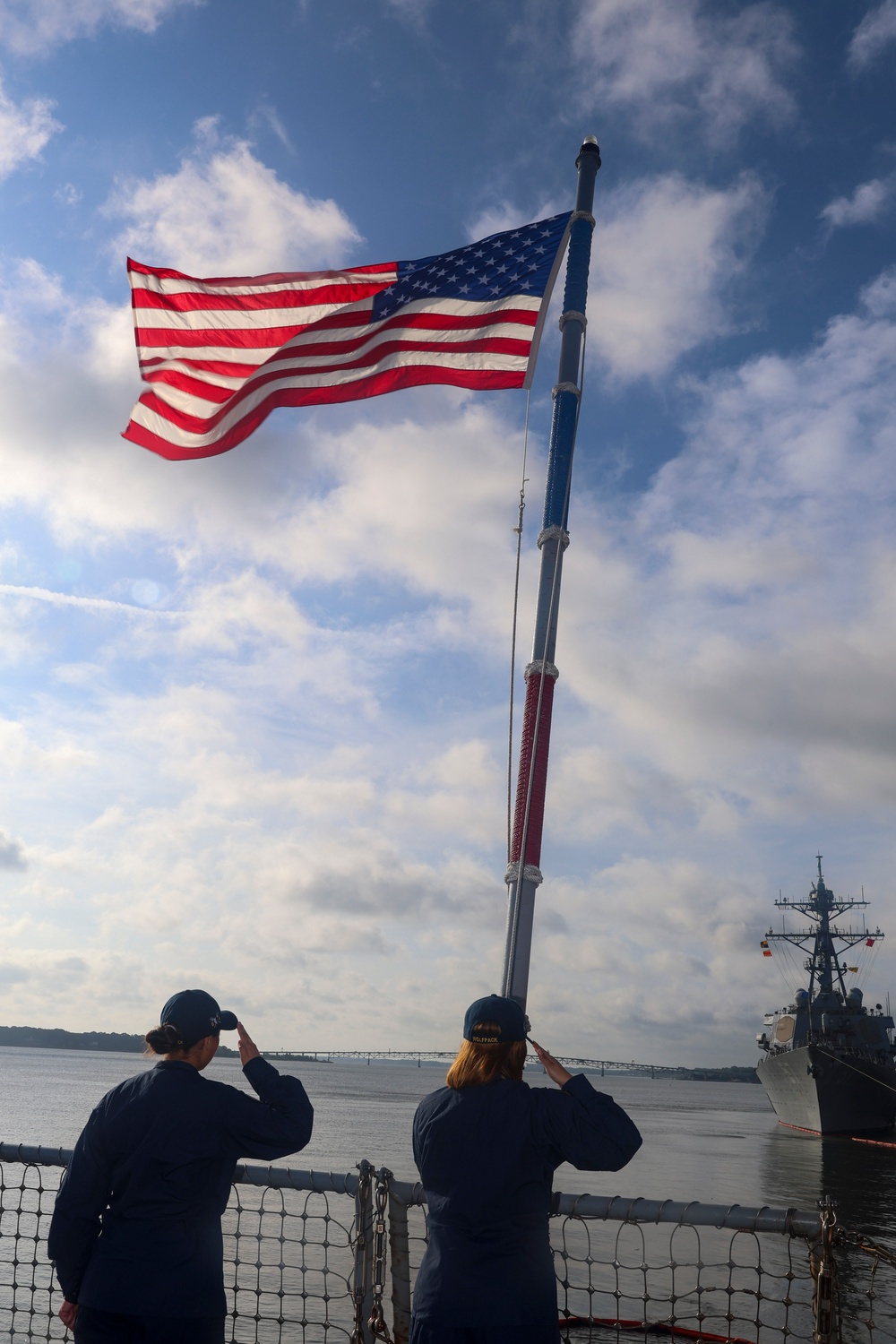 USS Bulkeley Sailors salute the ensign during morning colors on the aft flight deck