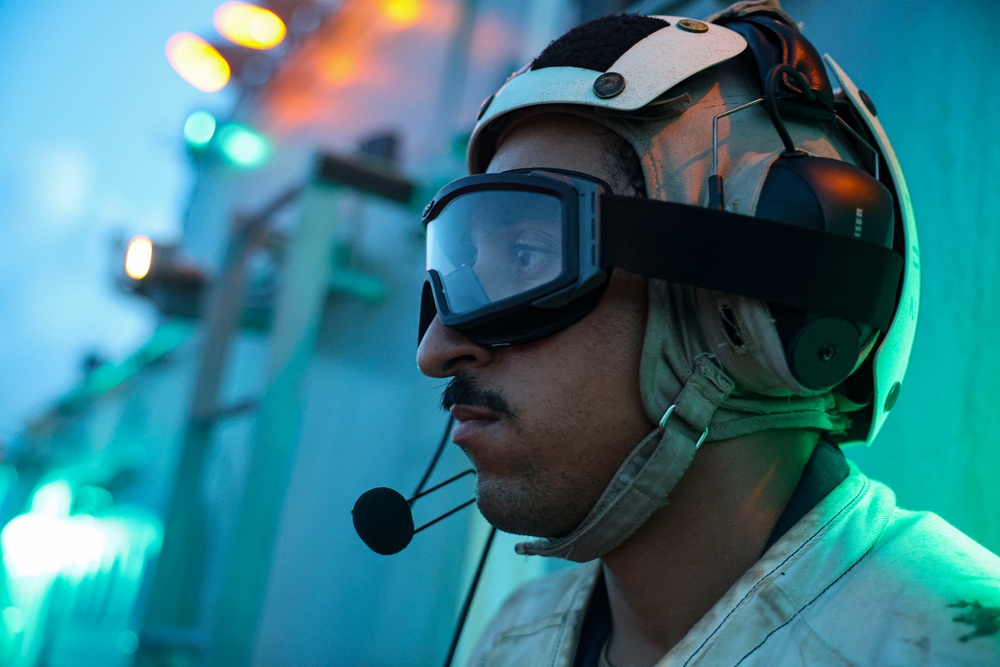 BM1 Youssef Belakbir communicates with MH-60R Seahawk pilots during flight operations