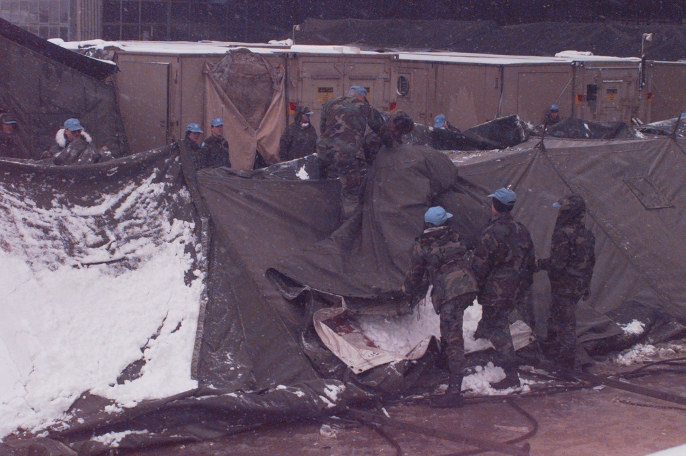 Members of the 74th Medical Group remove the red cross at the U.S. Hospital Zagreb, Croatia