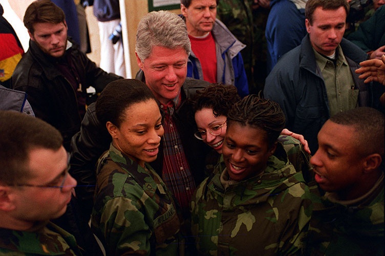 U.S. Army soldiers get in close for a photo with President Bill Clinton.