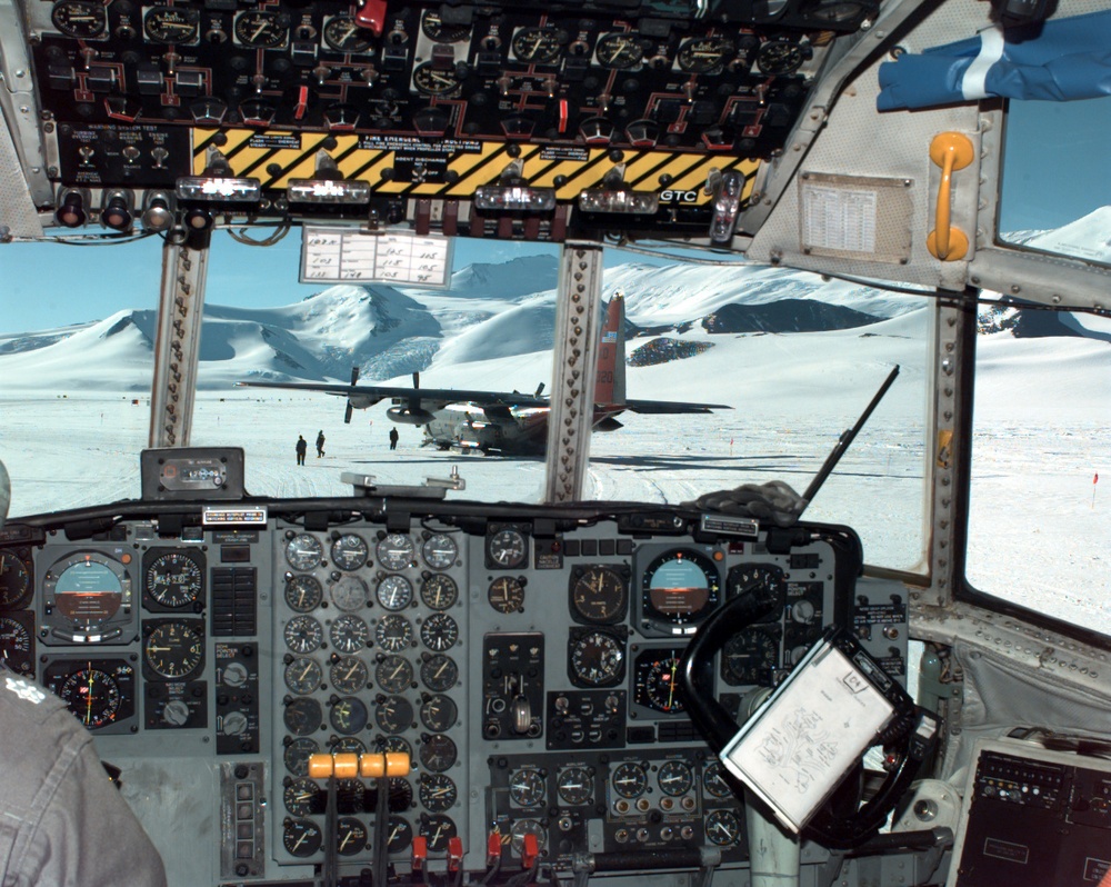 U.S. Navy LC-130 Hercules ski-equipped cargo plane seen through the cockpit of another Hercules.