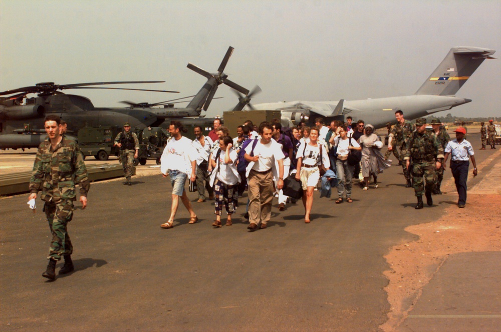 Evacuees from Liberia are led away from a U.S. Air Force MH-53 Pavelow.