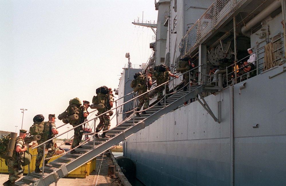 U.S. Marines climb the brow of the USS Whidbey Island (LSD 41).