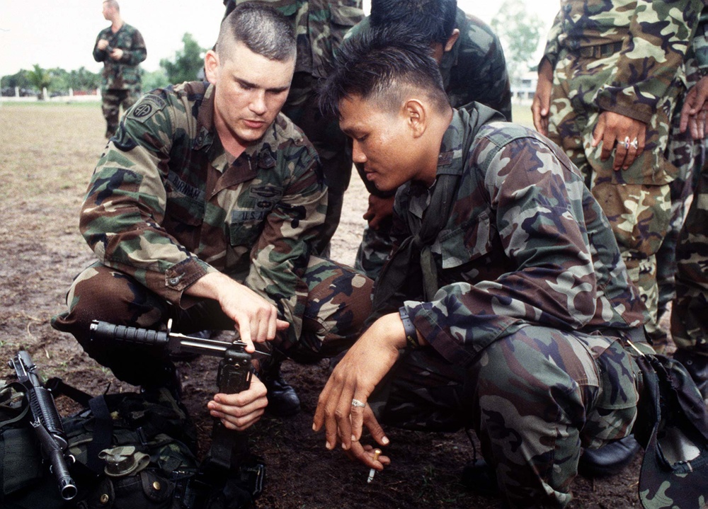 U.S. Army Sgt. 1st Class Burnham explains a wire cutting technique to a Royal Thai Army soldier.