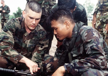 U.S. Army Sgt. 1st Class Burnham explains a wire cutting technique to a Royal Thai Army soldier.
