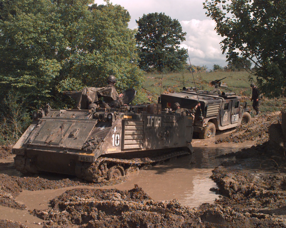 A U.S. Army M-113 APC prepares to pull a Humvee out of the mud in Bosnia and Herzegovina.