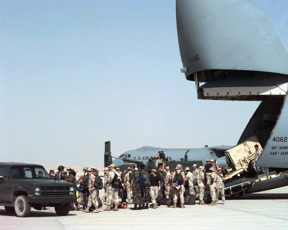 C-5B Galaxy unloads support personnel and equipment at Al Kharj, Saudi Arabia.