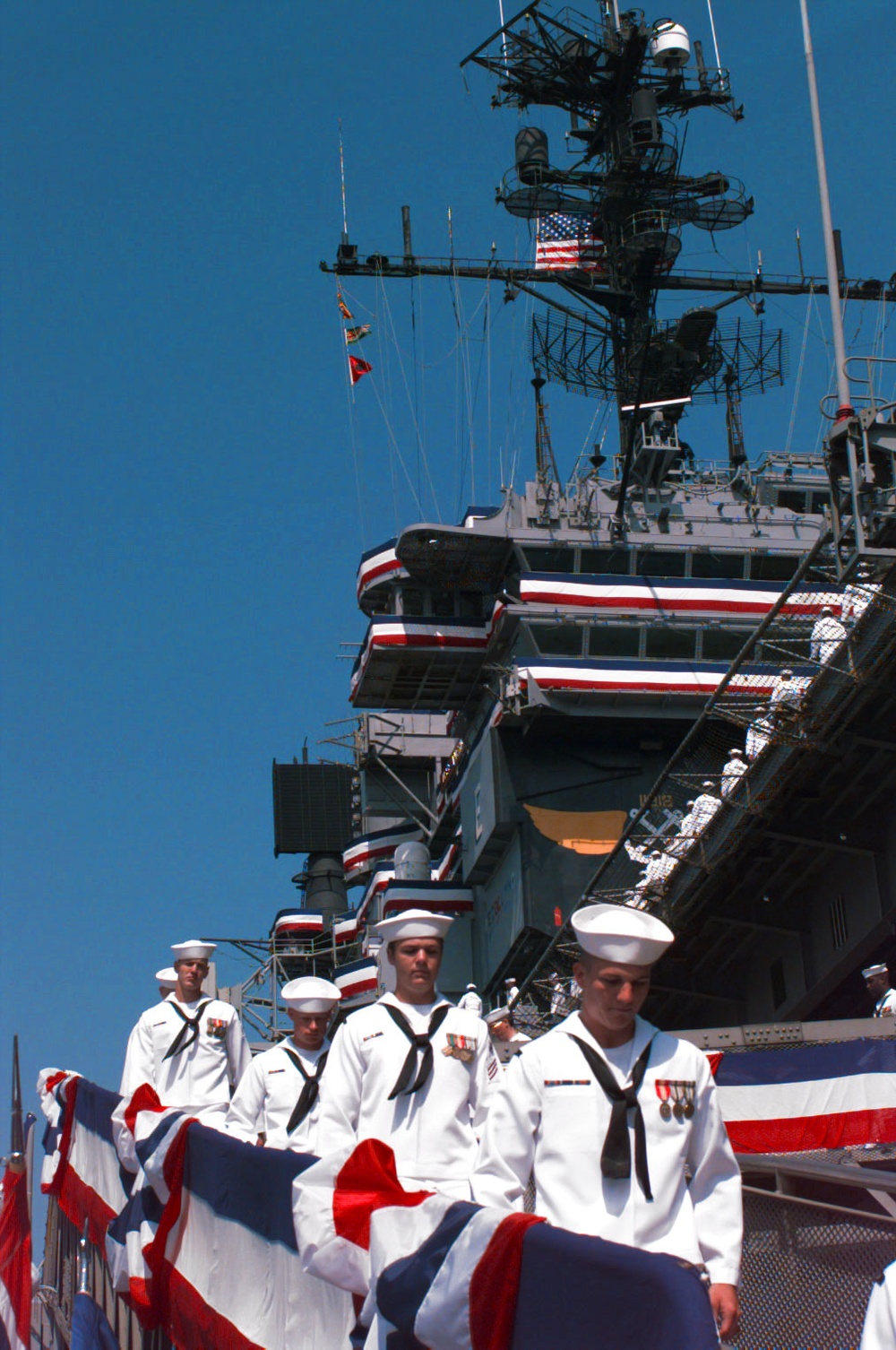 The crew of the USS America marches down the gangway for the last time.