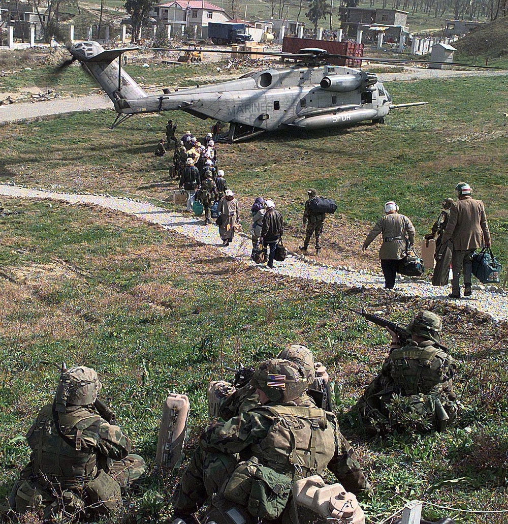 American evacuees walk to a U.S. Marine Corps CH-53 helicopter in Tirana, Albania.