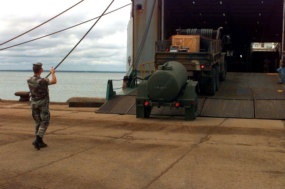 A Marine guides the driver of a M-923A2 5-ton truck and its trailer in Paldiski, Estonia.