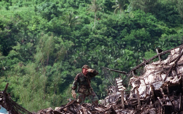 A rescuer works atop the wreckage of KAL Flight 801