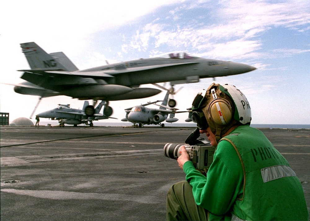 U.S. Navy Photographer's Mate uses a video camera to document Nimitz flight ops.