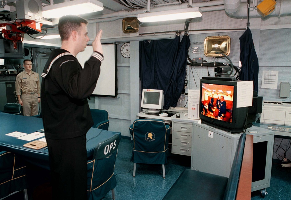 Father in Virginia reenlists son in Persian Gulf via video link.