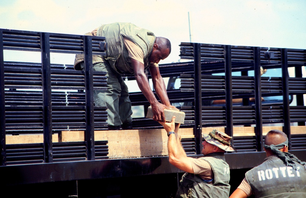 Marines unload deactivated anti-tank and anti-personnel land mines for destruction.
