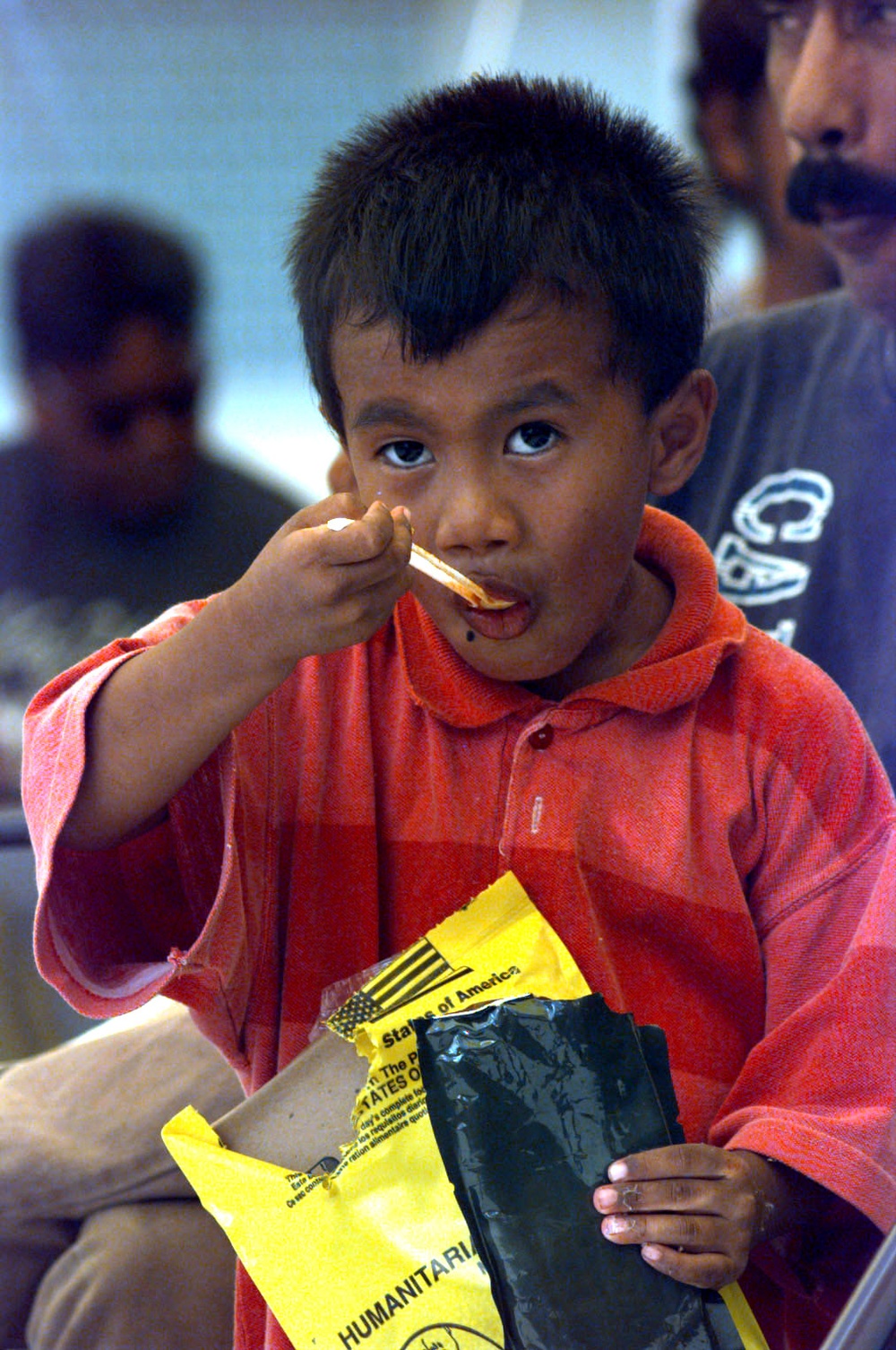 A little boy has a Humanitarian Meal Ready to Eat at Andersen Air Force Base, Guam.