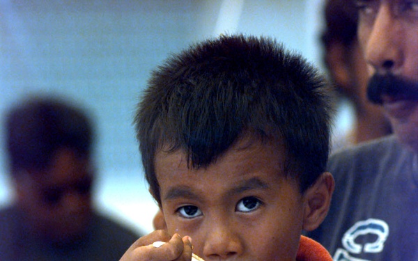 A little boy has a Humanitarian Meal Ready to Eat at Andersen Air Force Base, Guam.