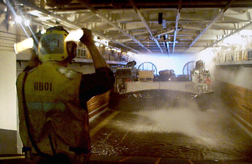 Petty Officer Smith guides a Landing Craft Air Cushion into the well deck of the USS Wasp.