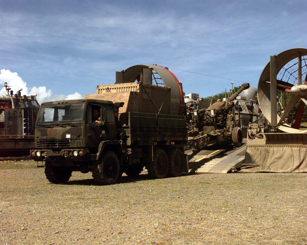 U.S. Army soldiers pull a M-198 155 mm howitzer off of a U.S. Navy LCAC.