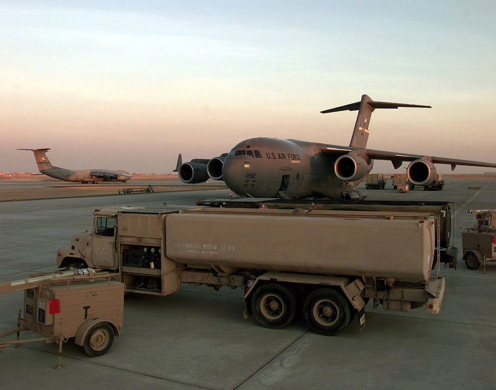 A C-141 Starlifter taxis in to join a C-17 Globemaster III at an operating base in Southwest Asia.