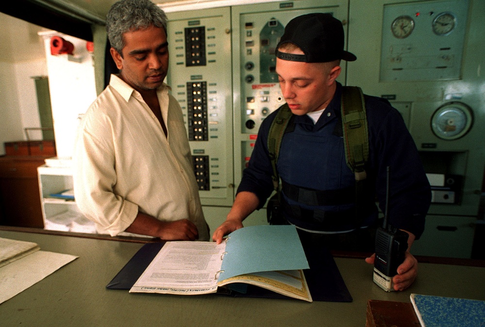 Lt. j.g. Watson talks to the master of an Iranian cargo ship as he inspects the ship's documents.