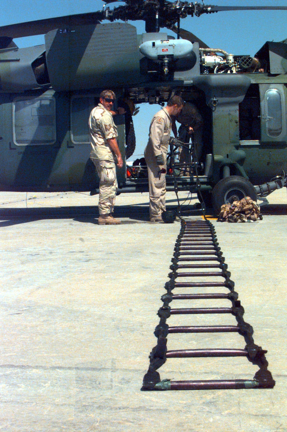 Maintenance and aircrew members check equipment for a MH/HH-60G Pave Hawk.