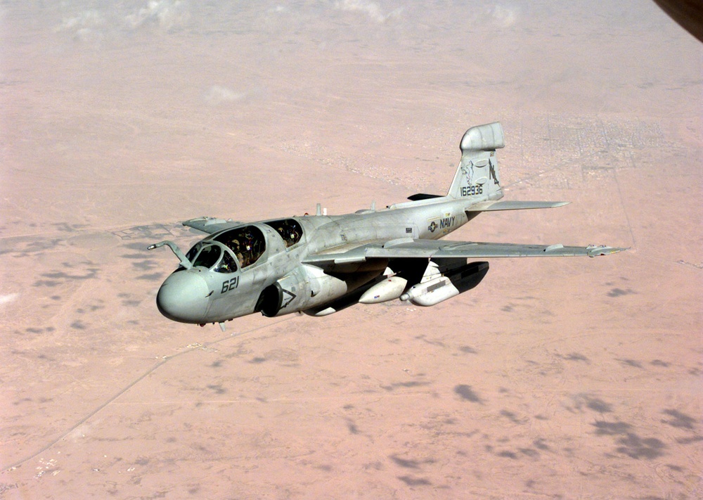 A Navy Prowler drops away from an Air Force Stratotanker over the desert of Saudi Arabia.
