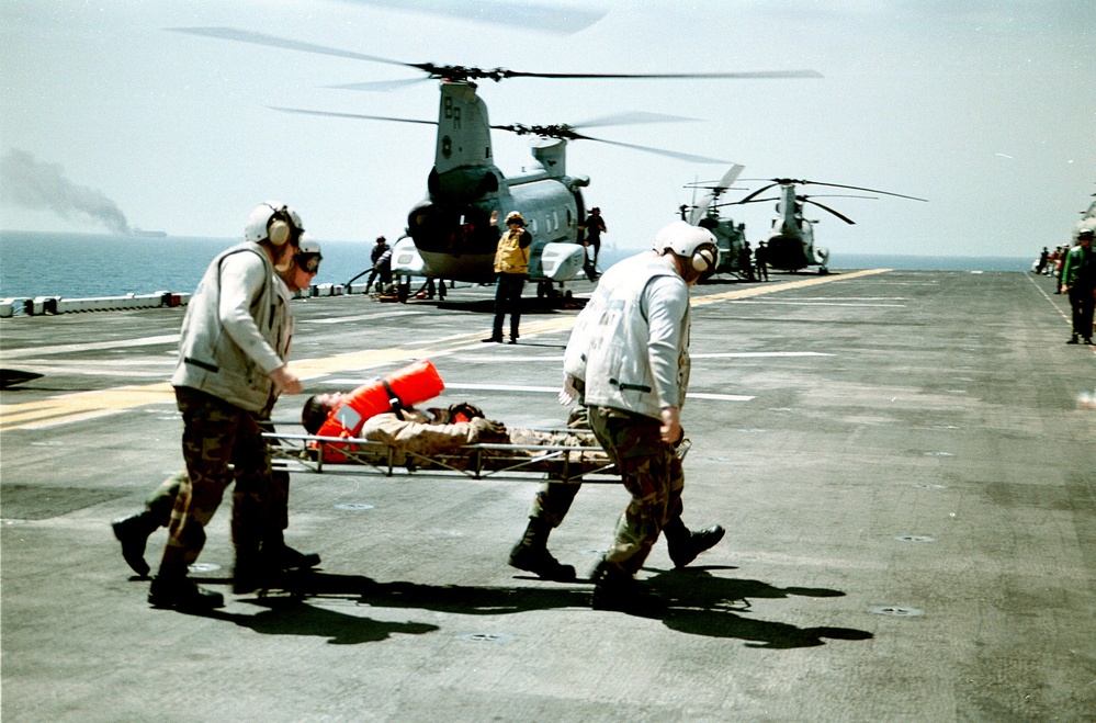 U.S. Marines rush an injured Seal-Land Mariner sailor to sickbay aboard the USS Wasp.