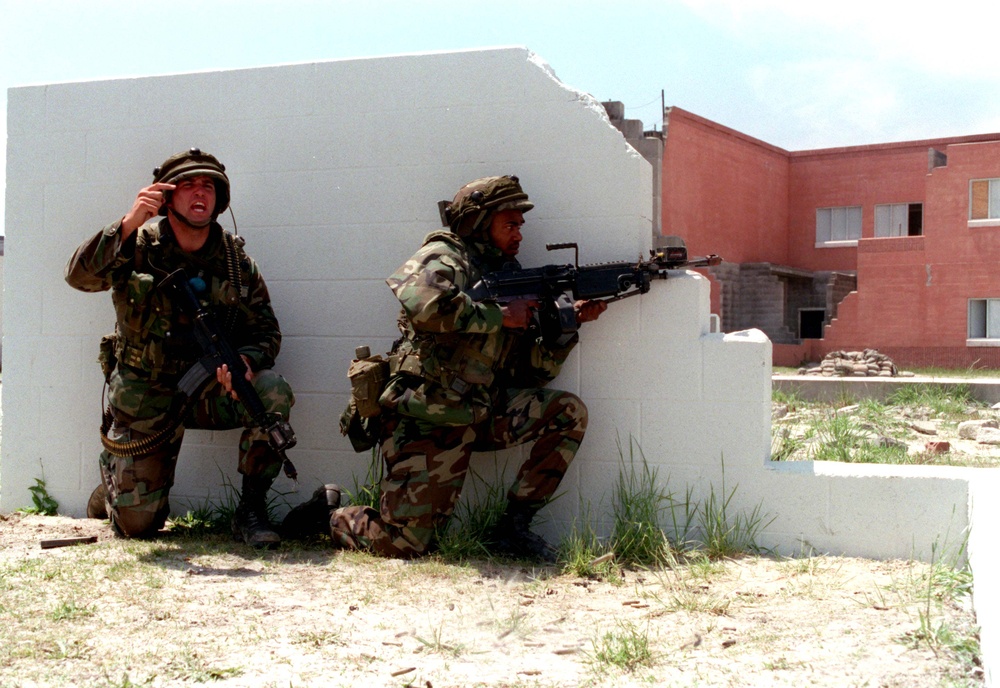 Cpl. Kramer signals for backup as Lance Cpl. Pentacola fires his M-249 Squad Automatic Weapon.