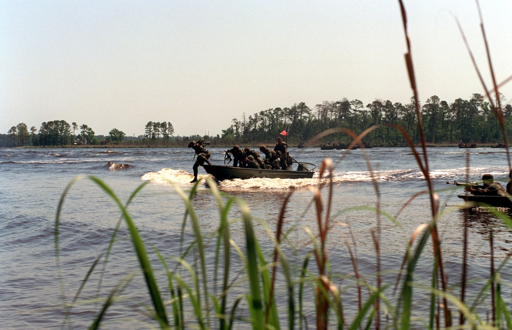 U.S. Marines jump out of Rigid Raiding Craft as they begin a raid on the New River shoreline.