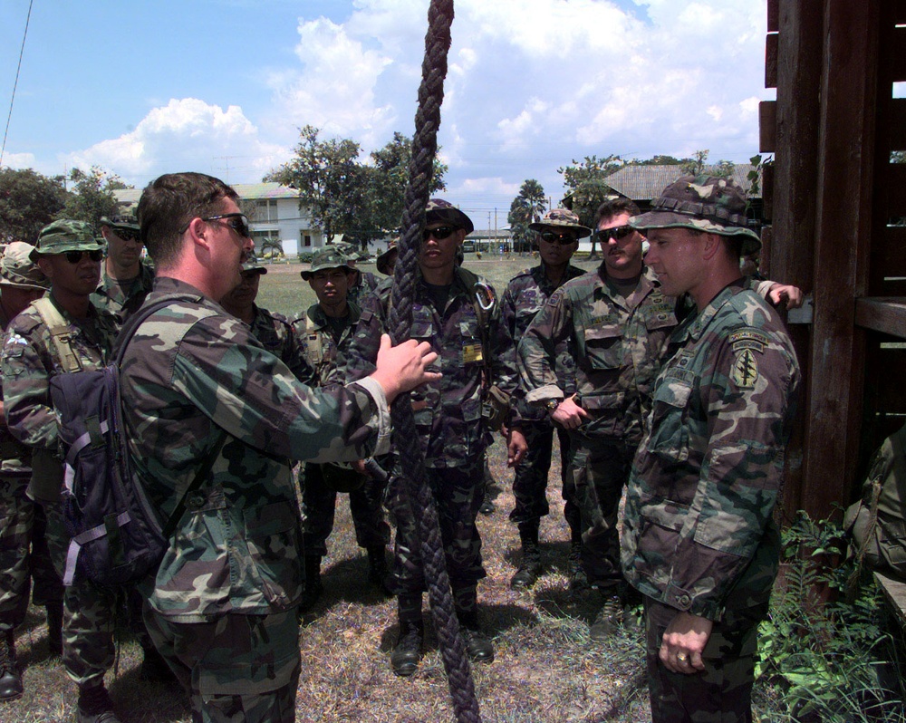 U.S. Army sergeants brief Royal Thai Special Forces personnel on fast-rope training.