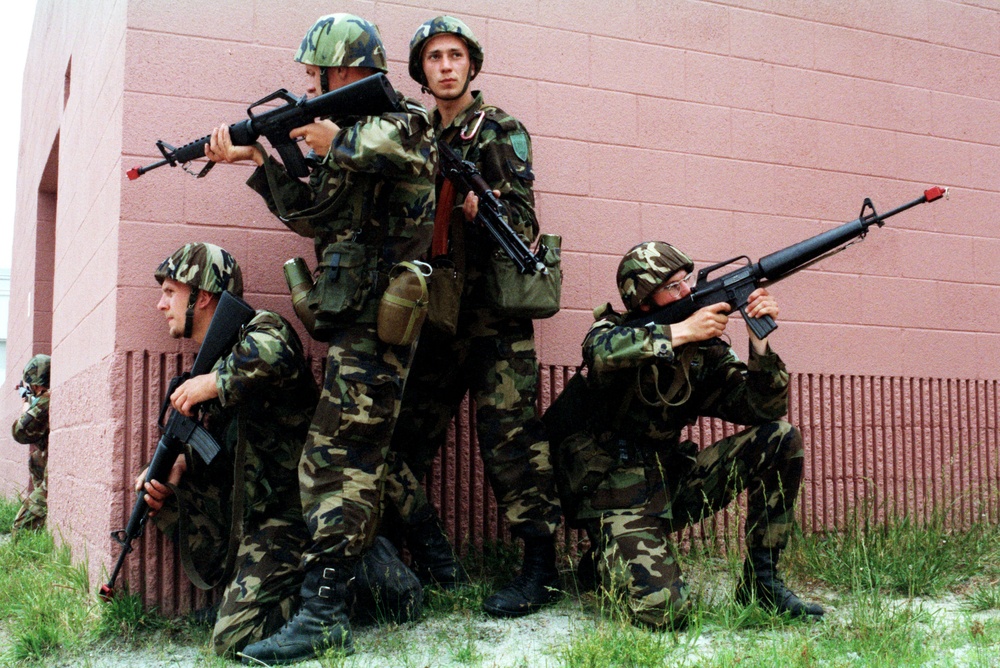 Four Latvian soldiers keep a sharp look out in the Military Operations in Urban Terrain facility.